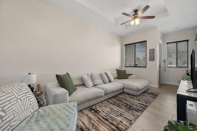 living room featuring ceiling fan and a tray ceiling