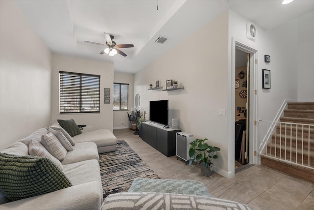 living room featuring ceiling fan and a tray ceiling