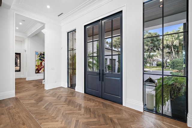 entryway with parquet floors, a wealth of natural light, ornamental molding, and french doors