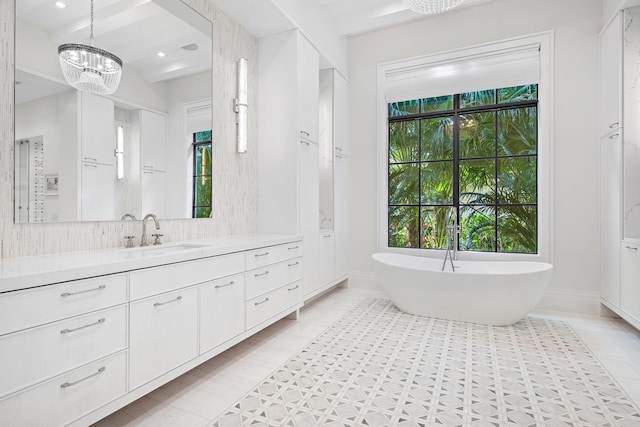 bathroom featuring vanity, a tub, a wealth of natural light, and a chandelier