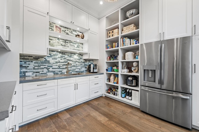 kitchen with sink, white cabinets, dark stone counters, stainless steel refrigerator with ice dispenser, and dark wood-type flooring