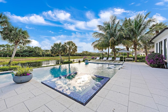 view of pool featuring a patio and a water view