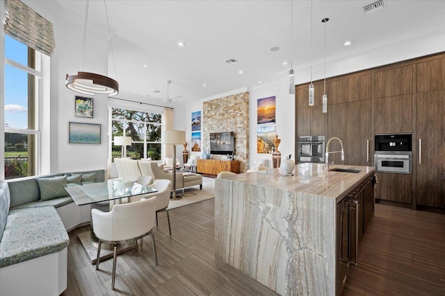 kitchen featuring breakfast area, sink, plenty of natural light, and an island with sink