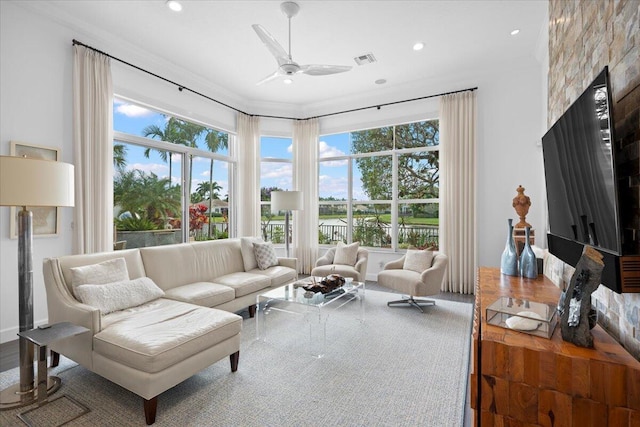 living room featuring ornamental molding, a wealth of natural light, and ceiling fan