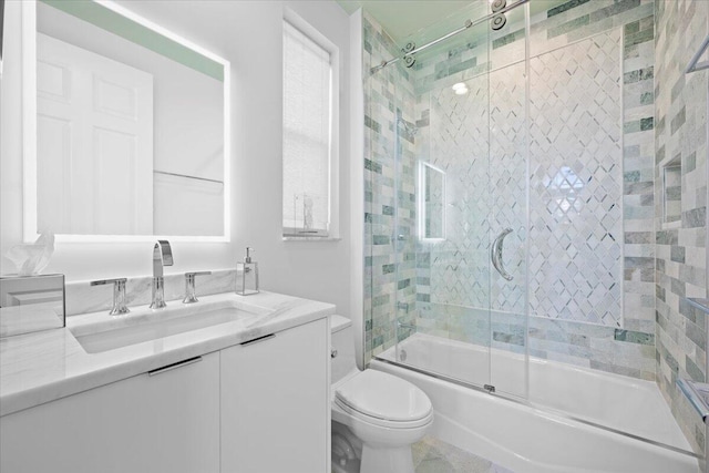 full bathroom featuring vanity, shower / bath combination with glass door, and toilet