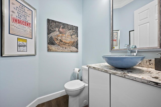 bathroom with ornamental molding, toilet, hardwood / wood-style floors, and vanity