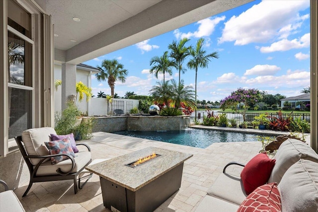 view of pool featuring pool water feature, a patio area, and a fire pit