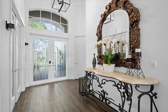 foyer featuring dark hardwood / wood-style flooring, french doors, and a chandelier