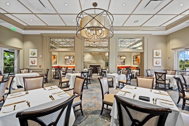 carpeted dining room with an inviting chandelier, coffered ceiling, and a high ceiling