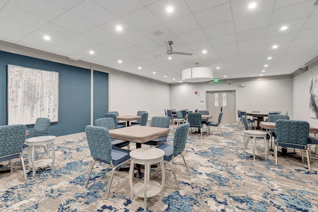 carpeted dining room featuring ceiling fan and ornamental molding