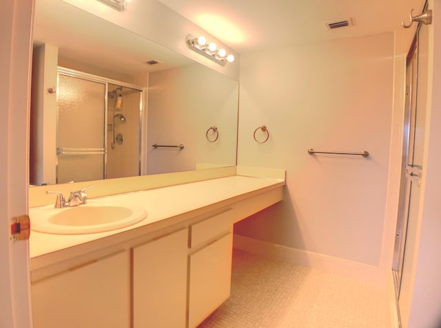 bathroom with tile patterned floors, a shower with shower door, and vanity