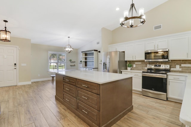 kitchen featuring white cabinetry, hanging light fixtures, stainless steel appliances, and a kitchen island