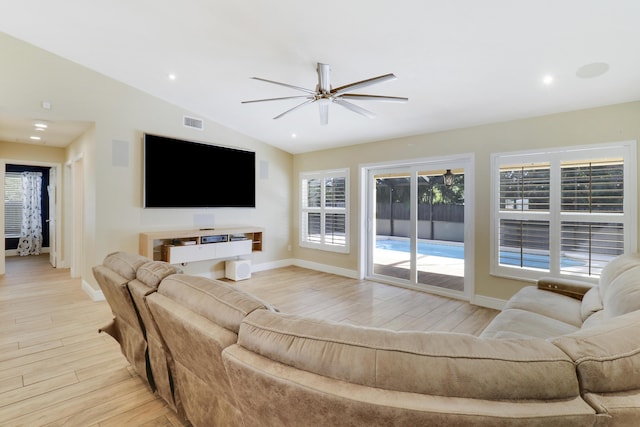 living room with ceiling fan, vaulted ceiling, and light hardwood / wood-style flooring