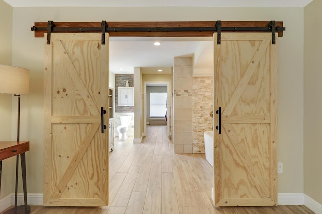 hallway featuring light hardwood / wood-style flooring and a barn door