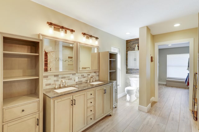 bathroom featuring toilet, hardwood / wood-style floors, tasteful backsplash, and vanity