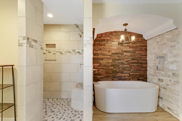 bathroom with hardwood / wood-style flooring, ornamental molding, a notable chandelier, and plus walk in shower