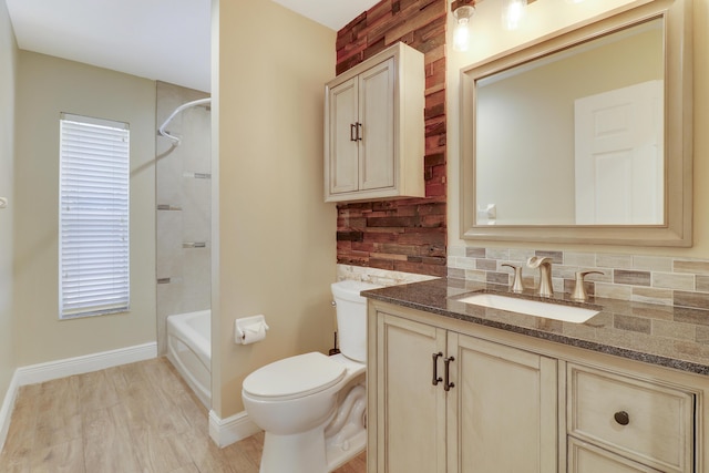 full bathroom with tiled shower / bath, vanity, backsplash, toilet, and hardwood / wood-style flooring