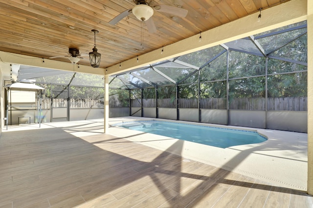 view of pool featuring ceiling fan, glass enclosure, and a patio