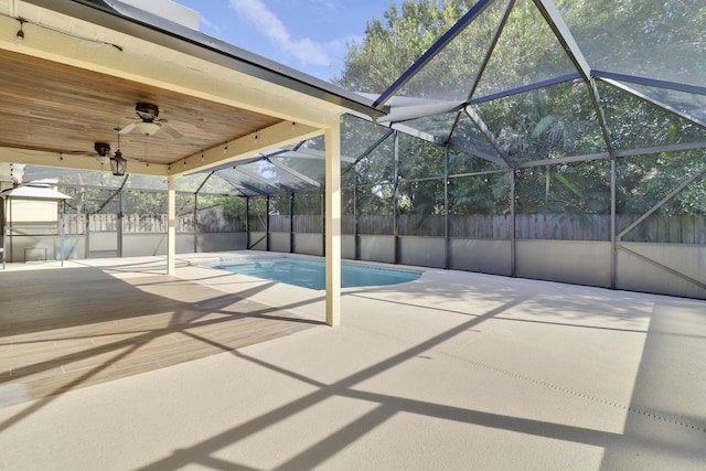 view of pool featuring a patio area, glass enclosure, and ceiling fan