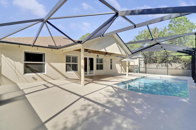 view of pool with ceiling fan, a patio area, and glass enclosure