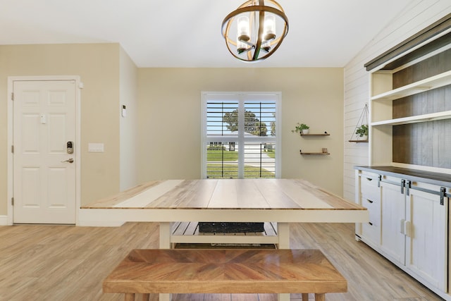 unfurnished dining area with light hardwood / wood-style flooring, a chandelier, and vaulted ceiling