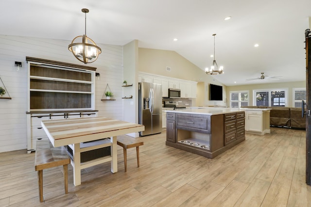 kitchen featuring appliances with stainless steel finishes, pendant lighting, white cabinets, and a center island