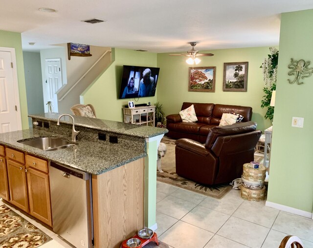 kitchen with ceiling fan, dishwasher, sink, an island with sink, and light tile patterned floors