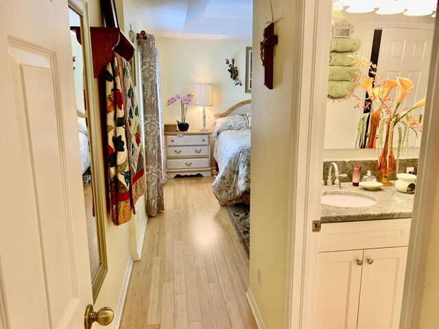 bedroom featuring sink and light wood-type flooring