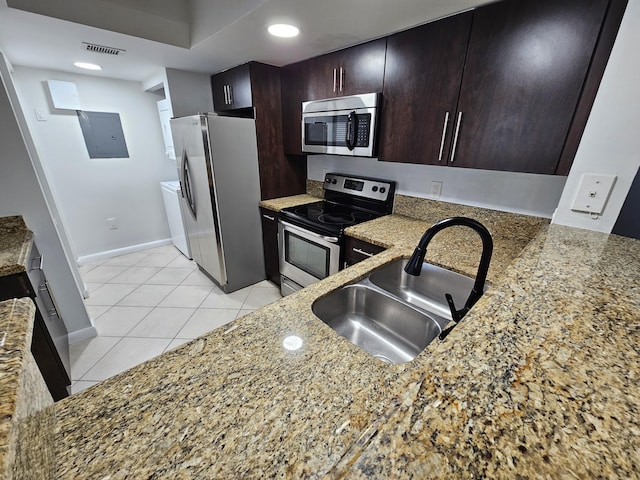 kitchen featuring appliances with stainless steel finishes, electric panel, light stone counters, sink, and light tile patterned flooring