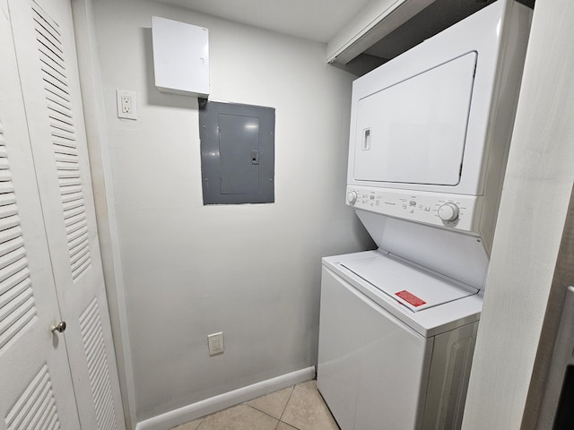 laundry room featuring electric panel, light tile patterned floors, and stacked washer and dryer