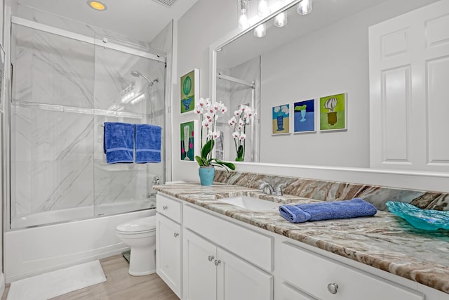 full bathroom with vanity, wood-type flooring, enclosed tub / shower combo, and toilet