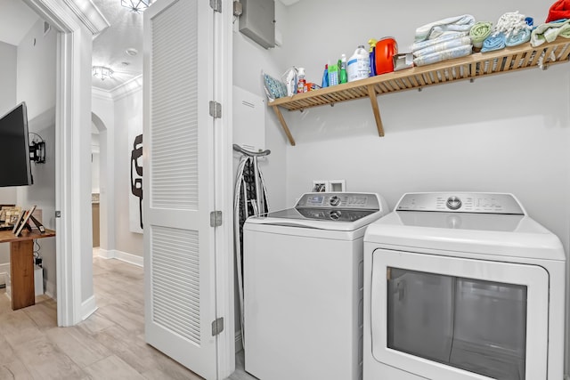 washroom with crown molding, light hardwood / wood-style floors, and independent washer and dryer