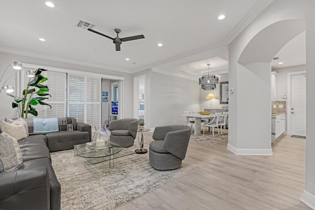 living room featuring crown molding, ceiling fan, and light wood-type flooring