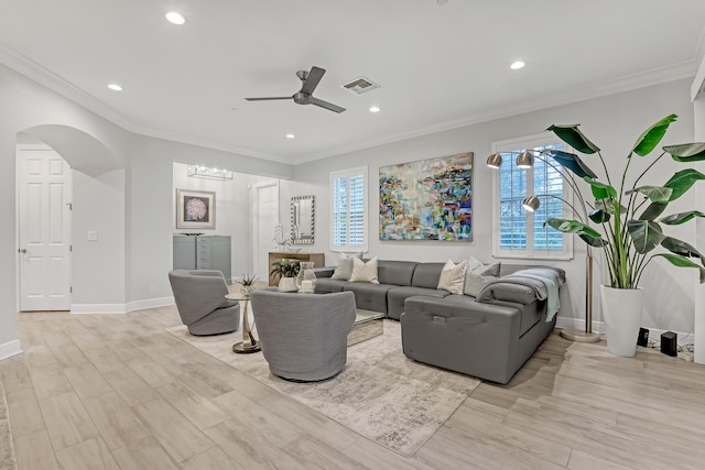 living room with ornamental molding, a wealth of natural light, and light hardwood / wood-style flooring