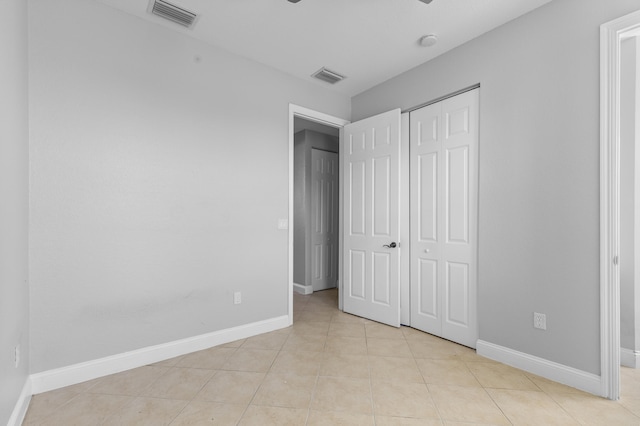 unfurnished bedroom featuring a closet and light tile patterned flooring