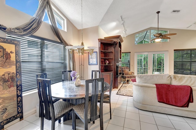 dining room featuring lofted ceiling, light tile patterned floors, french doors, and ceiling fan with notable chandelier