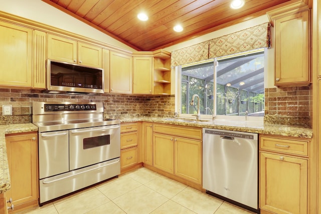 kitchen with lofted ceiling, sink, appliances with stainless steel finishes, light brown cabinets, and light tile patterned floors