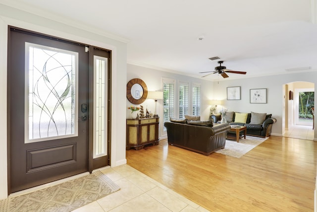 entryway with ceiling fan, crown molding, and light hardwood / wood-style flooring