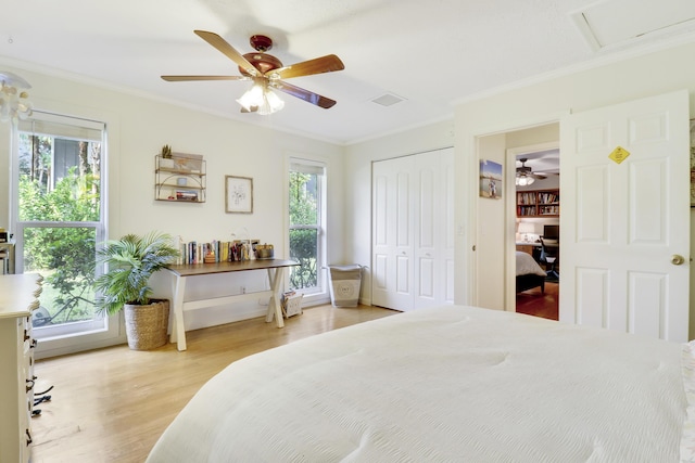 bedroom featuring ceiling fan, a closet, ornamental molding, and light hardwood / wood-style floors