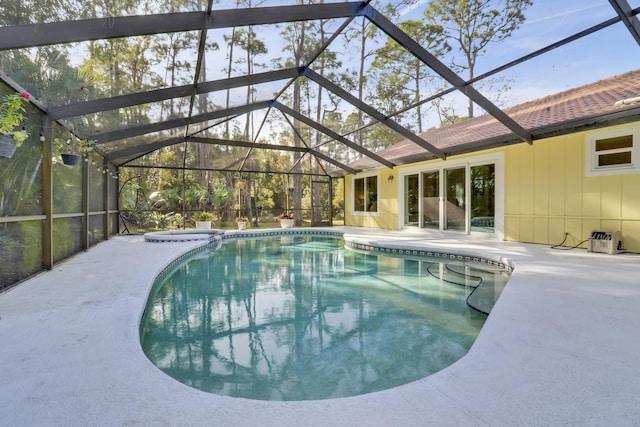 view of pool featuring glass enclosure, an in ground hot tub, and a patio