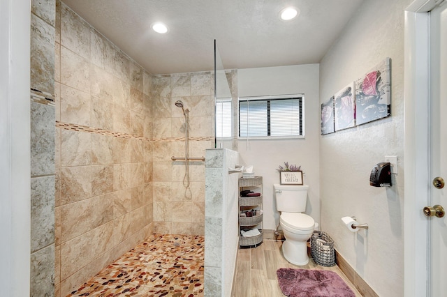 bathroom with tiled shower and toilet