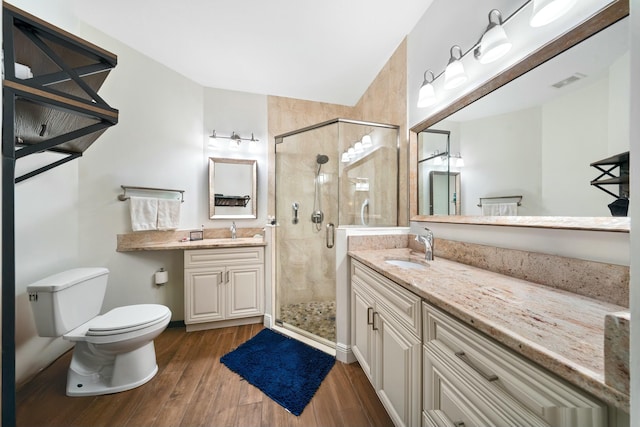 bathroom with hardwood / wood-style flooring, toilet, a shower with door, and vanity