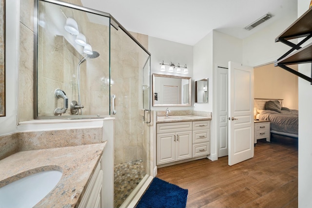 bathroom featuring wood-type flooring, an enclosed shower, and vanity