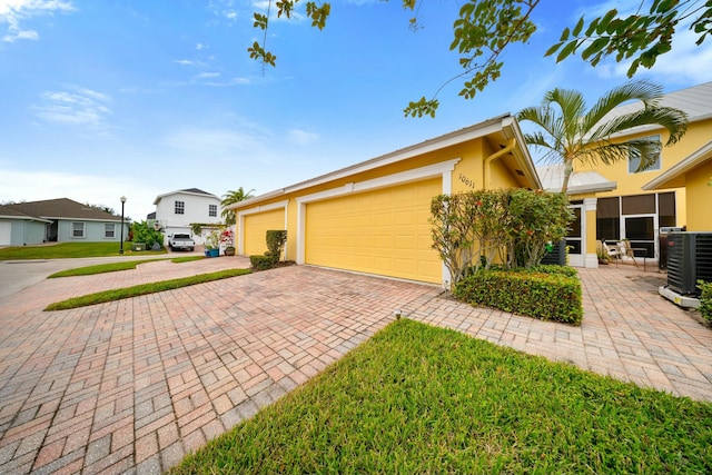 view of front of house featuring a garage and central air condition unit