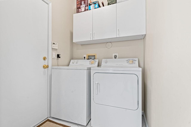 laundry room featuring cabinets and washing machine and clothes dryer