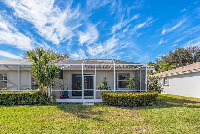 back of property with a lanai and a yard