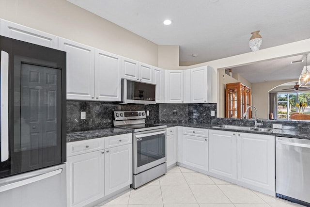 kitchen with sink, backsplash, stainless steel appliances, and white cabinets