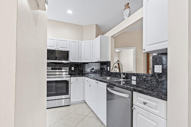 kitchen with backsplash, appliances with stainless steel finishes, sink, and white cabinets