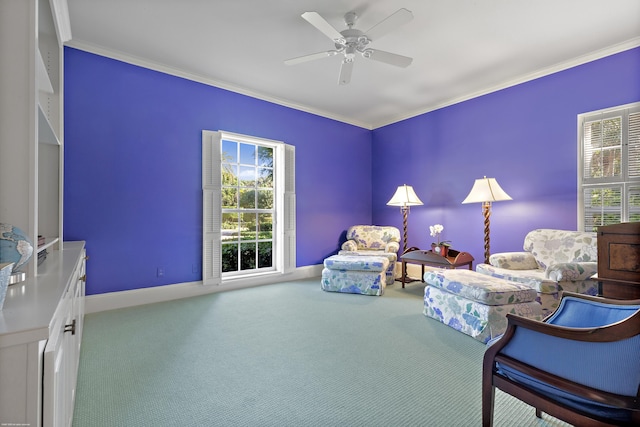 living area with ceiling fan, crown molding, and carpet floors