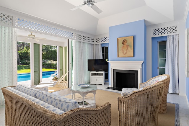 living room with ceiling fan, a raised ceiling, and lofted ceiling